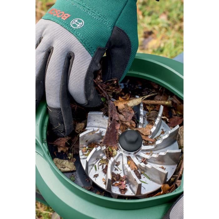 Broyeur de jardin Bosch rempli de feuilles, utilisé avec des gants pour un nettoyage efficace