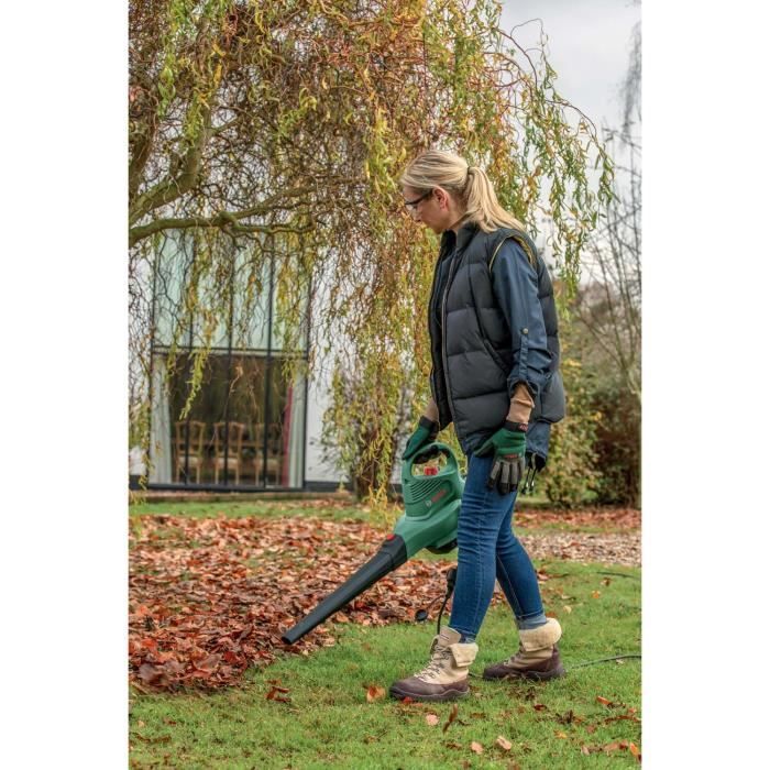 Femme utilisant un aspirateur souffleur broyeur Bosch dans un jardin d’automne