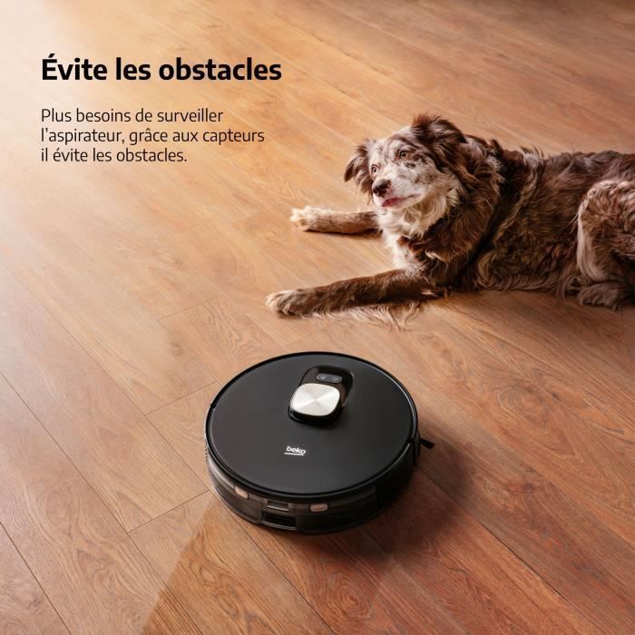 Aspirateur robot Beko VRR94314VB sur un sol en bois à côté d’un chien reposant