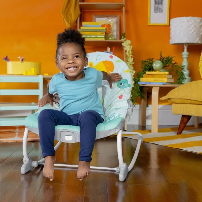 Enfant souriant dans un rocking chair coloré, mettant en avant les vibrations apaisantes