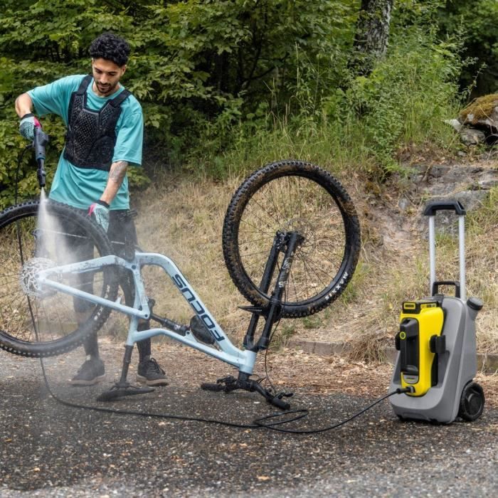 Personne utilisant un nettoyeur mobile moyenne pression sur un VTT avec KARCHER