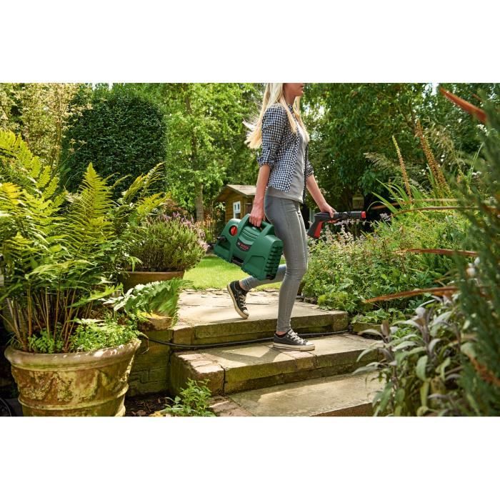 Femme avec un arrosoir vert dans un jardin, mettant en valeur le Nettoyeur Haute-Pression EasyAquatak