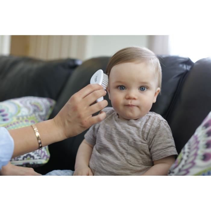 Bébé sur un canapé recevant un thermomètre du Kit Tommee Tippee pratique et hygiénique