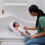 INGENUITY Asiento de baño antideslizante para niñas de 0 a 6 meses o 9 kg, asiento perforado para dejar fluir el agua, Rosa - immagine 2